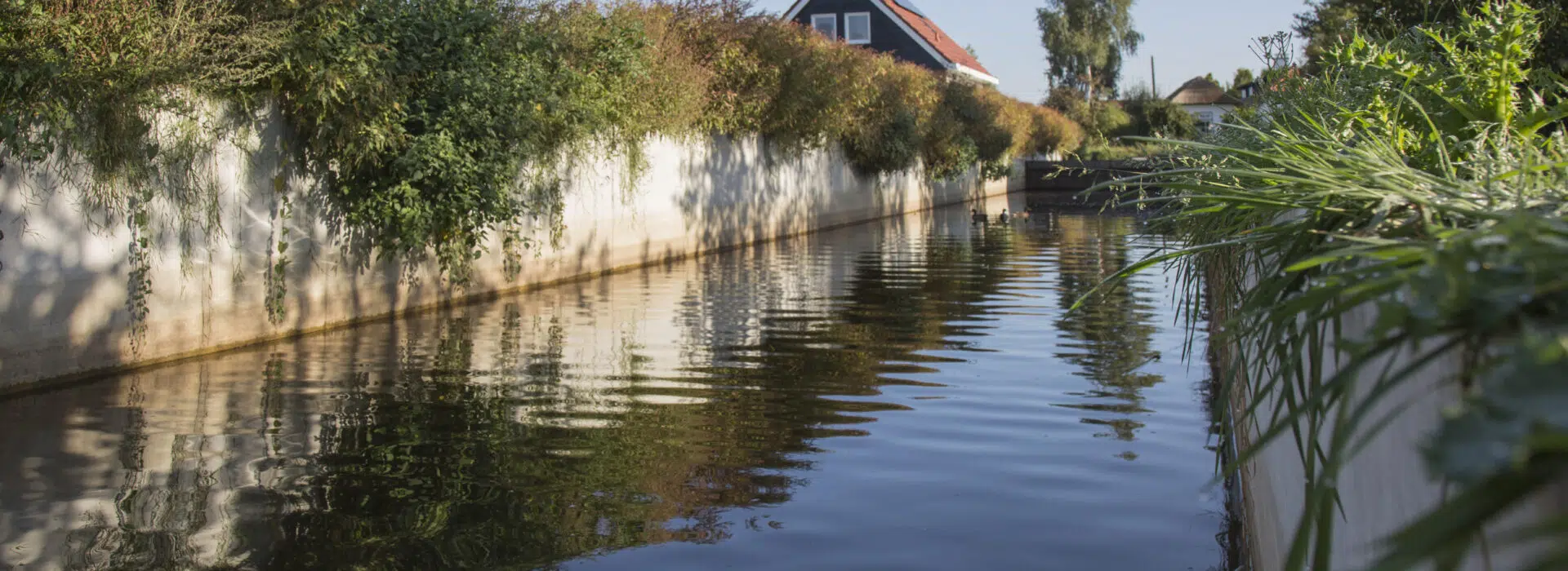Betonnen keerwand gebruikt als waterkering voor watergang