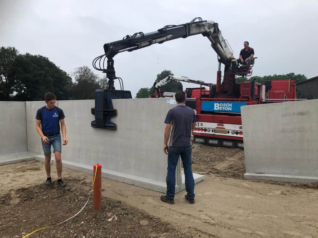 Montage von Silowänden für ein Fahrsilo mit Kran auf einem landwirtschaftlichen Betrieb