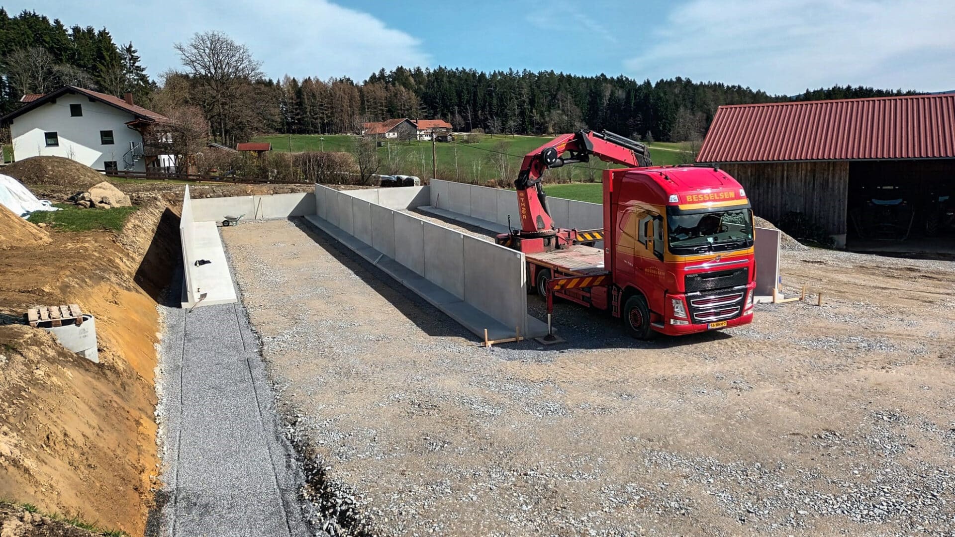 Montage von L-Steine für ein Fahrsilo auf einem landwirtschaftlichen Betrieb.