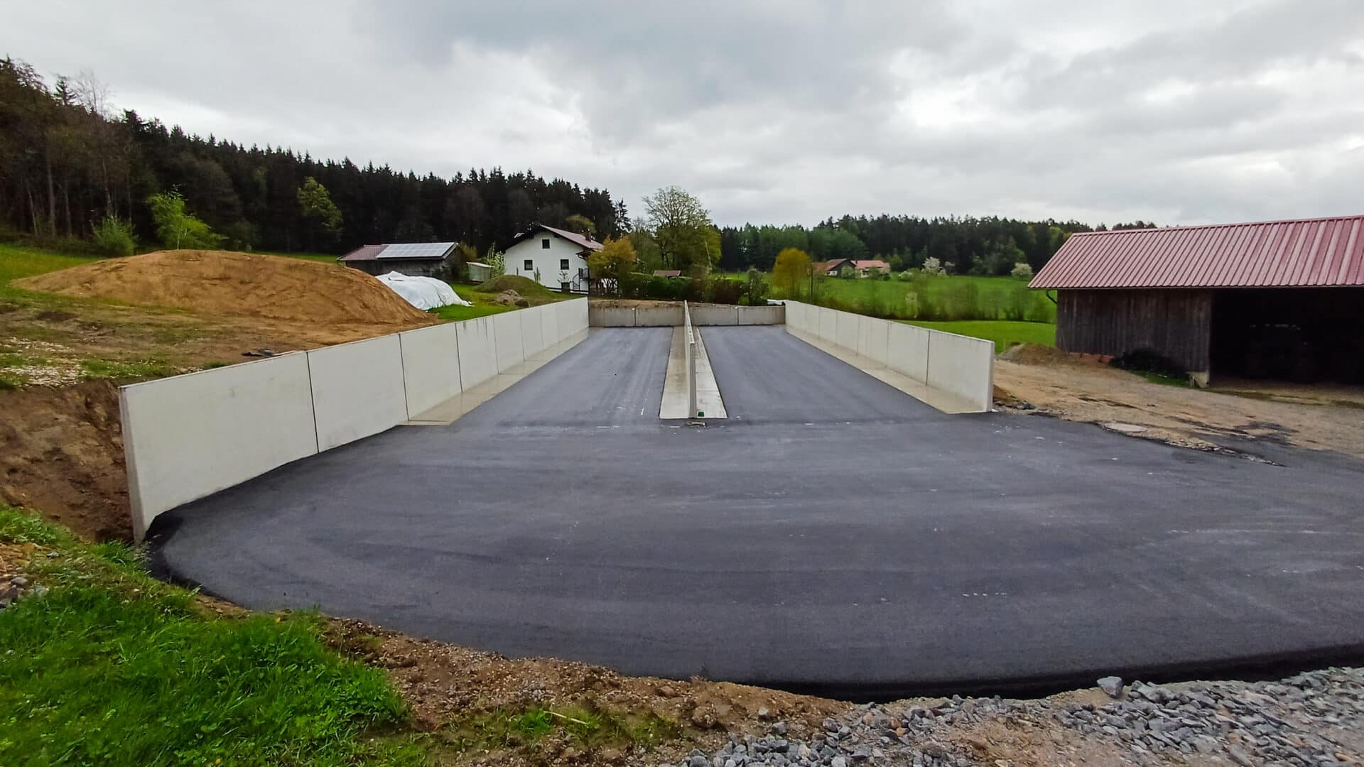 Fahrsilo mit Stützwänden und asphaltiertem Fahrsiloboden auf einem landwirtschaftlichen Betrieb.