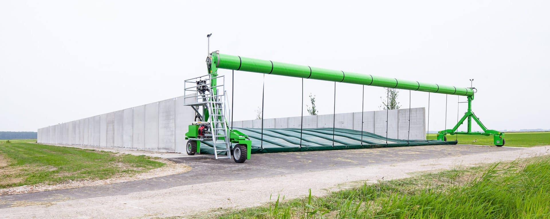 Fahrsilo mit automatischem Abdeckungssystem und Stützwänden auf einem landwirtschaftlichen Betrieb.