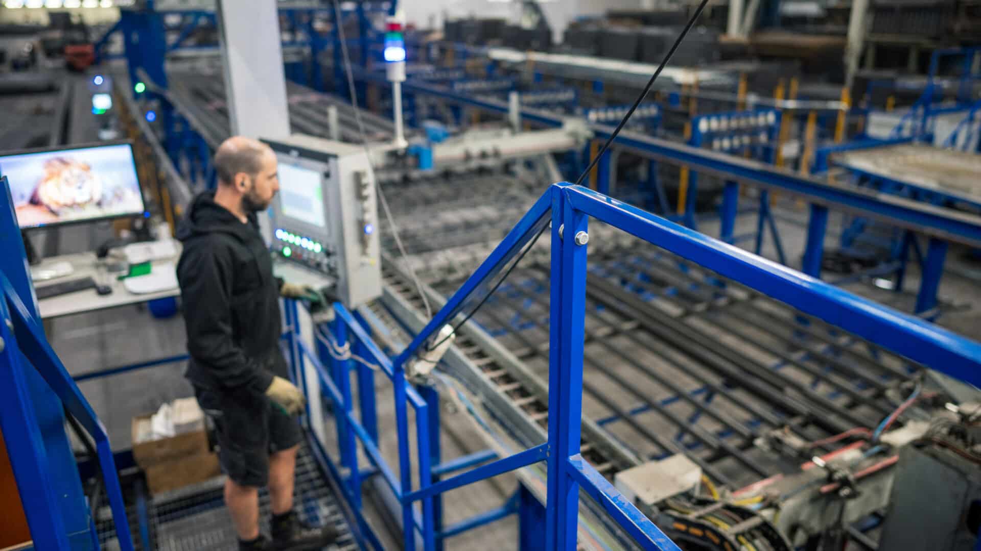 Mitarbeiter überwacht die neue Mattenschweißanlage in der Produktionshalle von Bosch Beton