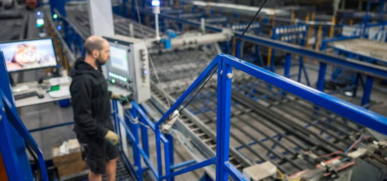 Mitarbeiter überwacht die neue Mattenschweißanlage in der Produktionshalle von Bosch Beton