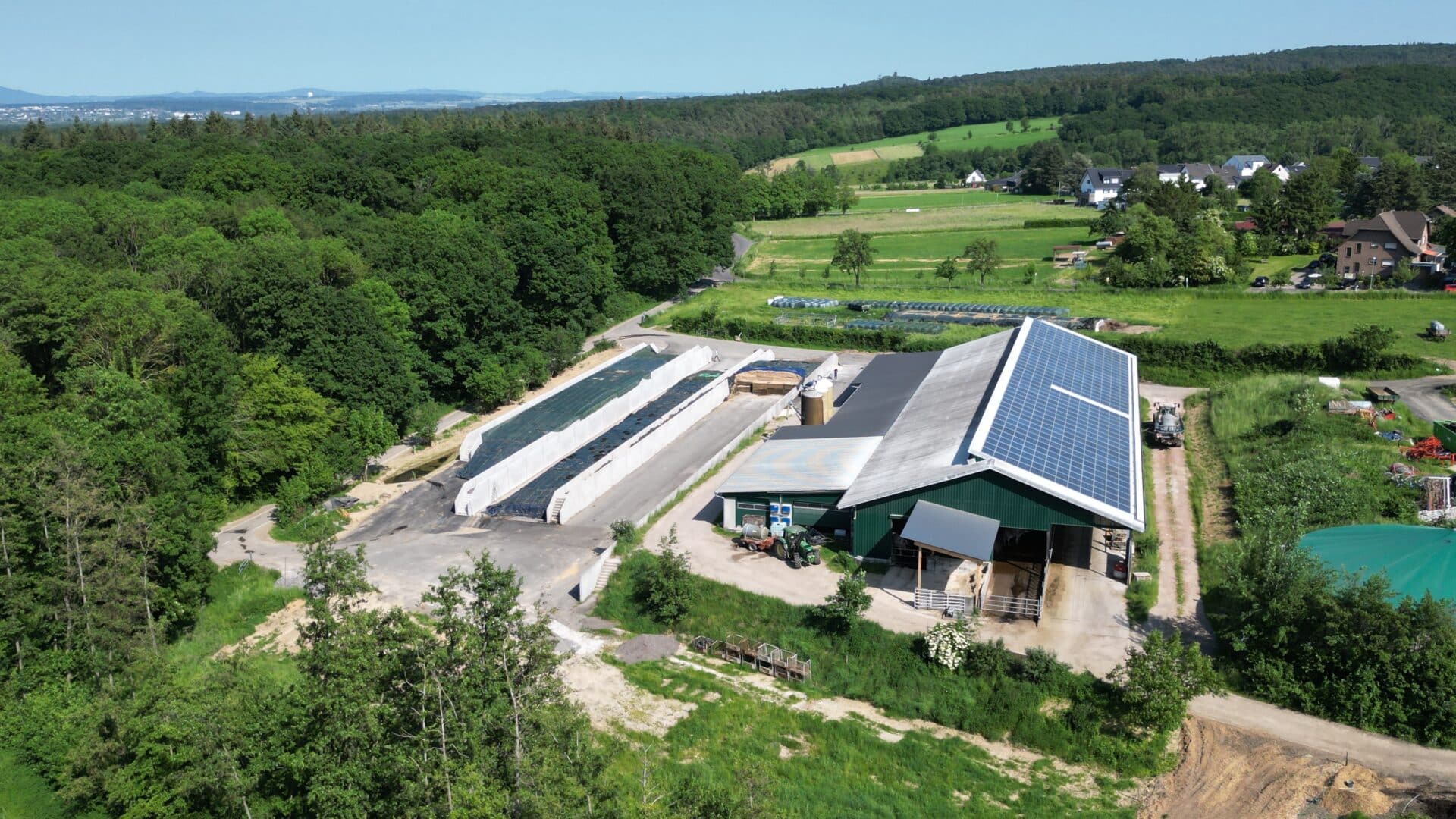 Luftaufnahme des Schlebacher Hofs mit Fahrsiloanlagen und landwirtschaftlichen Gebäuden