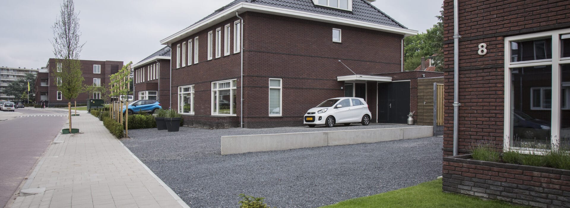 Bosch Beton - Niveauverschil opgevangen met keerwanden in oprit in woonwijk Soest