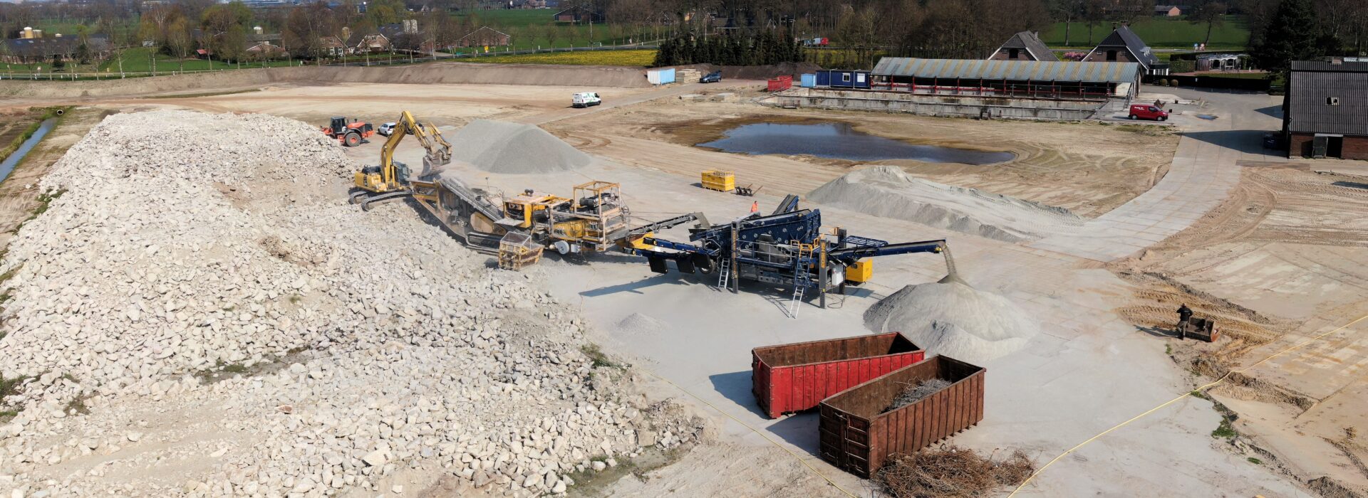 Machines verwerken fundamenten oude fabriek Bosch Beton in Kootwijkerbroek tot granulaat